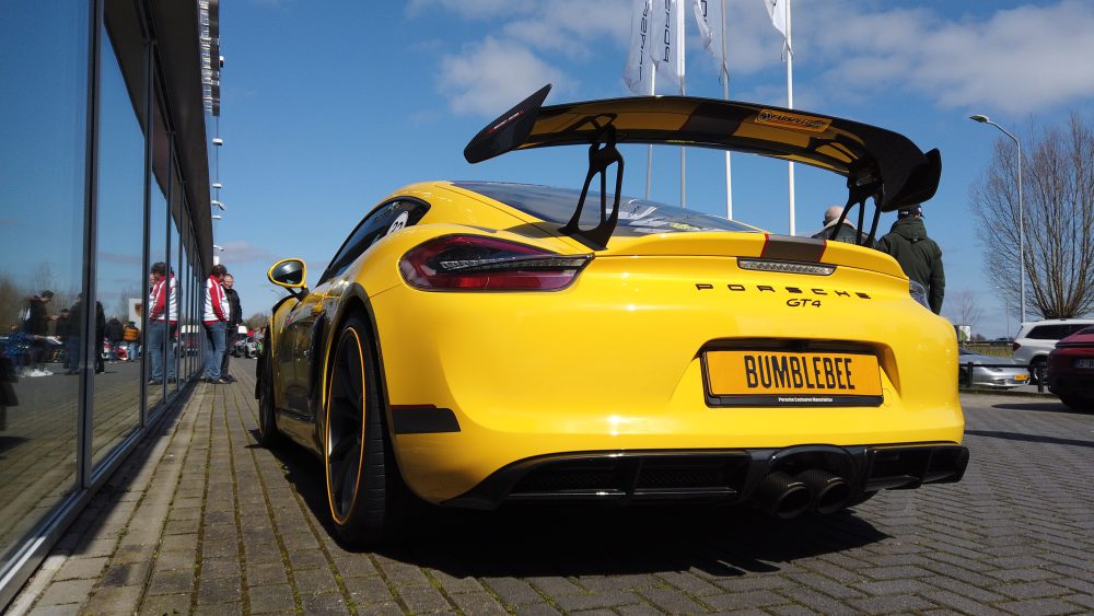 Achterzijde gele Porsche GT4, de grote achterspoiler is hier goed zichtbaar